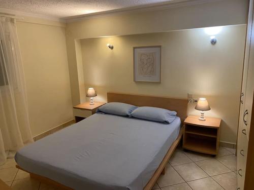 1 dormitorio con 1 cama grande y 2 mesitas de noche en Διαμέρισμα στο κέντρο της πόλης, en Chios