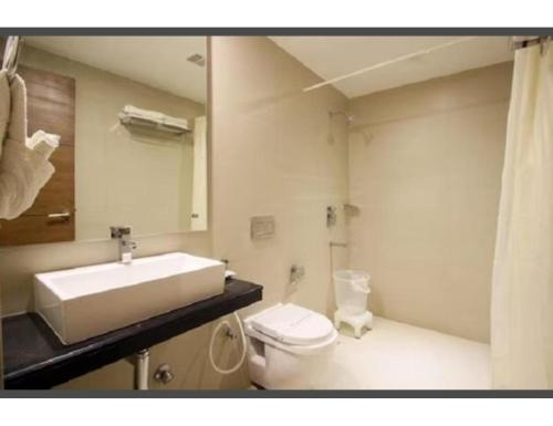 a bathroom with a sink and a toilet and a mirror at Hotel City Inn, Kakinada, Andhra Pradesh in Kākināda