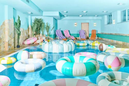 carpe solem KAPOOM - Pop Up Hotel till 2026 في كابرون: حمام سباحة مع كرات قابلة للنفخ في غرفة مع كراسي