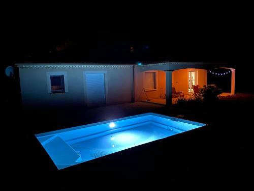 une photo de nuit d'une piscine devant une maison dans l'établissement Villa spacieuse avec piscine privé , Vallée du Lot, à Prayssac