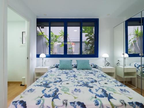 Un dormitorio con una cama grande y dos ventanas. en Suites Garden DALI 14, en Las Palmas de Gran Canaria