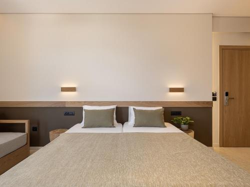 a bedroom with a large bed with two pillows at Esperides Beach Hotel Apartments in Stalos