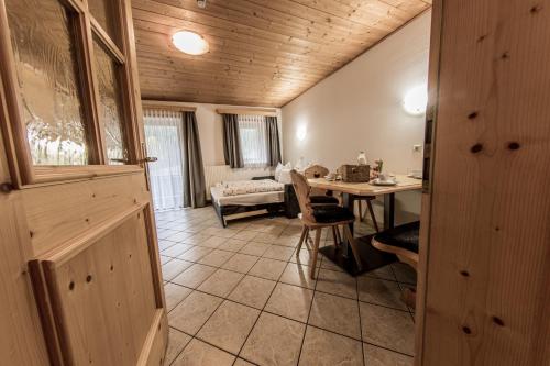 ein Wohnzimmer mit einem Tisch und einem Esszimmer in der Unterkunft Mösslhof App Garten in San Vito