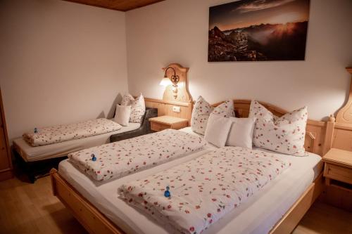 1 dormitorio con 2 camas y almohadas en Mösslhof App Garten, en San Vito