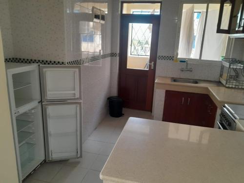 Il comprend une cuisine équipée d'un réfrigérateur et d'un comptoir. dans l'établissement Ocean one apartment, à Mombasa