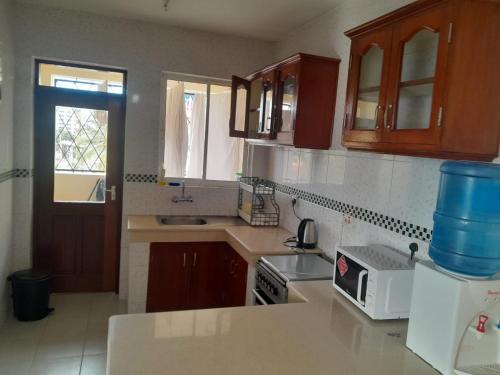 a kitchen with wooden cabinets and a counter top at Ocean one apartment in Mombasa