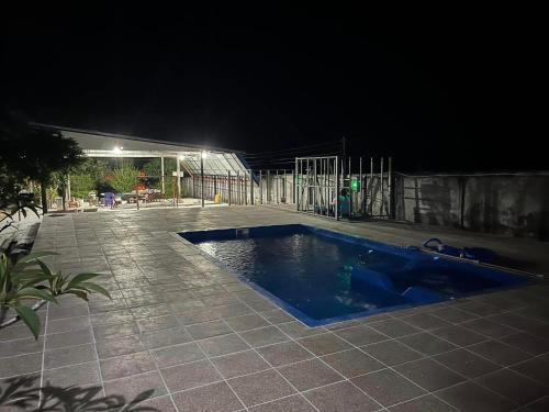 a swimming pool in the middle of a patio at night at แป๊ะชวนชิมรีสอร์ท สาขา 2 in Sirindhorn