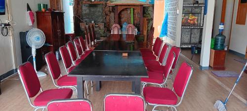 a conference room with a table and red chairs at PONDOK SITI RAWIYAH Guest House in Bukittinggi