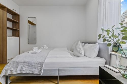 biała sypialnia z łóżkiem i oknem w obiekcie ma suite - smart apartment 2P - city Center w Augsburgu