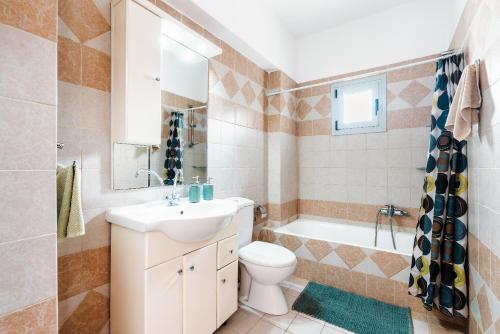 ein Badezimmer mit einem Waschbecken, einem WC und einer Badewanne in der Unterkunft Blue Pearl Apolakkia 1 in Apolakkiá