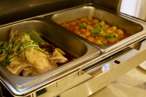 two trays of food in a toaster oven at Iris Dalat Hotel in Da Lat