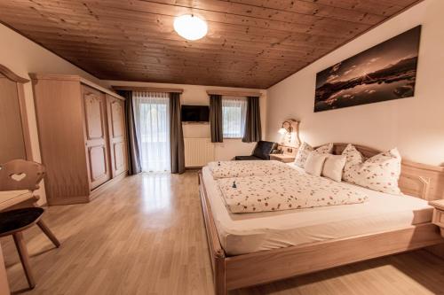 a bedroom with a large bed and a wooden ceiling at Mösslhof App Wiese in San Vito