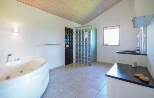 a large bathroom with a tub and a sink at Stunning Home In Spttrup With 4 Bedrooms, Sauna And Wifi in Knud