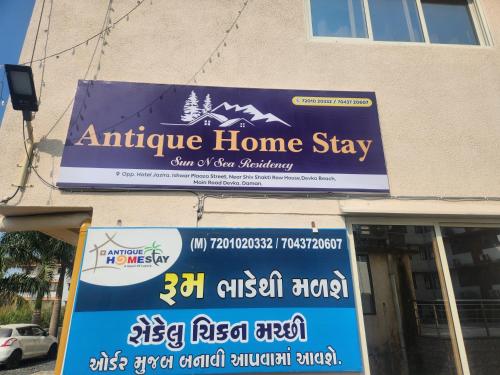 an antigua home stay sign on the side of a building at Antique Home Stay in Daman