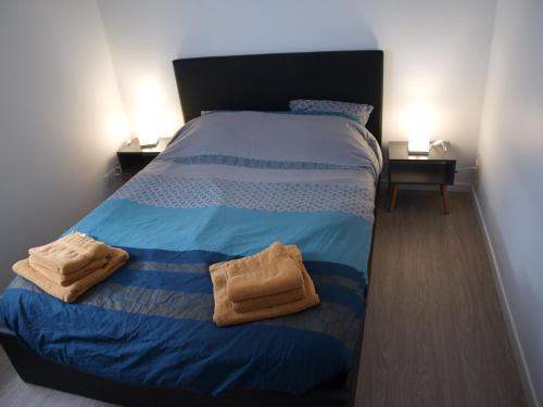 - un lit dans une chambre avec 2 serviettes dans l'établissement Appartement terrasse jardin rive gauche du port, à Vannes