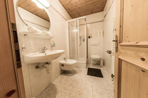 a bathroom with a sink and a shower and a toilet at Mösslhof App Wiese in San Vito