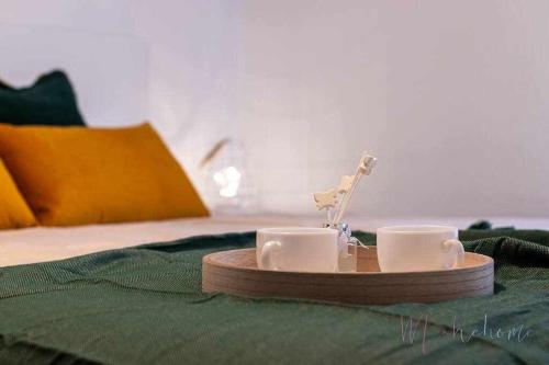 a tray with two cups on top of a bed at A estrenar pleno centro, parking in Huelva