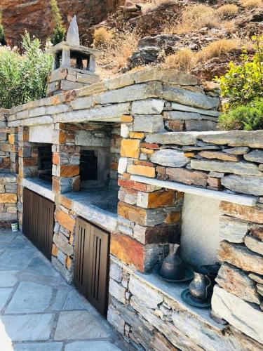 an outdoor brick oven with a stone wall at Villa Faros Vourkari Kea with private pool and stunning views in Vourkarion