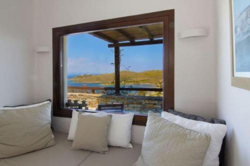 a room with pillows and a window with a view at Villa Faros Vourkari Kea with private pool and stunning views in Vourkarion