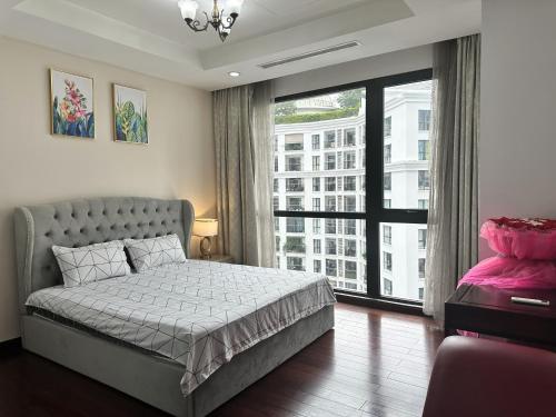 um quarto com uma cama e uma grande janela em Paradise Home Royal City em Hanói