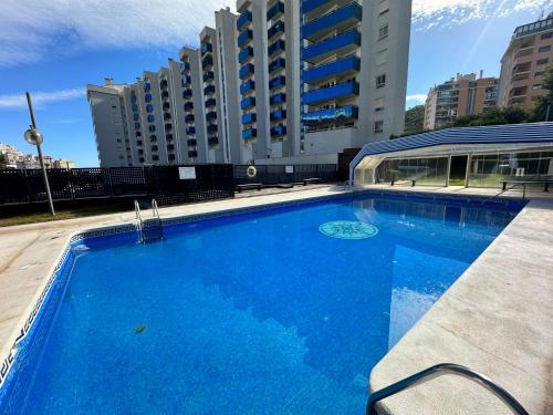 einem großen blauen Pool vor einem Gebäude in der Unterkunft Seaview apartment Cala de Finestrat - Vista al mar in Villajoyosa