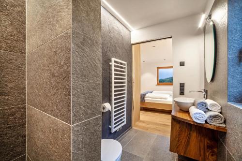 uma casa de banho com um chuveiro e um lavatório. em Huetterhof Apartement Winter em Caines