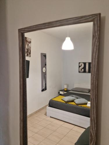 un miroir reflétant une chambre avec un lit dans l'établissement Magnanimo room, à Palerme