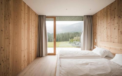 1 dormitorio con 2 camas y ventana grande en Karerhof en Nova Levante