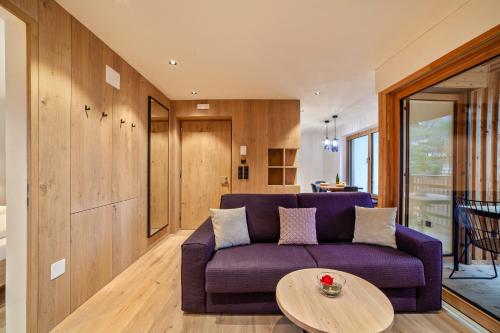a living room with a purple couch and a table at Huetterhof Apartement Winter in Caines