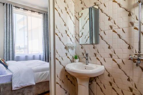 a bathroom with a sink and a mirror at Cozy & Stylish 1-Bedroom Apartment by Havana Properties located in Kinondoni Vijana in Dar es Salaam