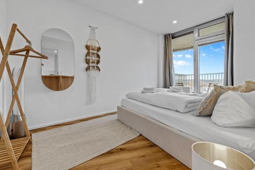 a white bedroom with a large bed and a window at ma suite -NEW-23Floor-FantasticView-Center in Augsburg