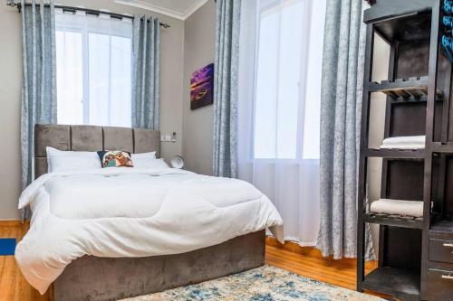 a bedroom with a bed and a large window at Cozy & Stylish 1-Bedroom Apartment by Havana Properties located in Kinondoni Vijana in Dar es Salaam
