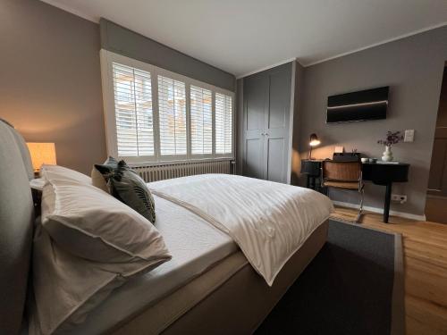 1 dormitorio con 1 cama, ventana y escritorio en Premium Apartment an der Stadtmauer im EG en Paderborn