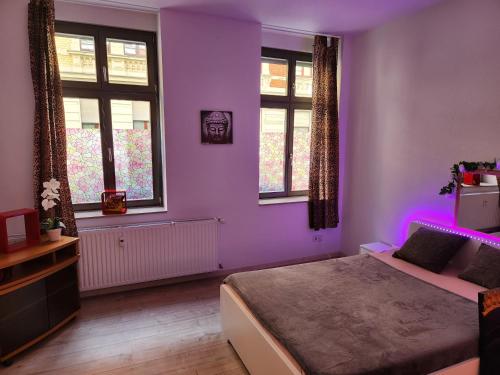 a bedroom with purple walls and a bed and windows at MD- Bukau Günstige 1 oder 2 e c h t e Schlafzimmer mit extra Küche u Bad für relax und verliebte von 18 bis 99 Jahre in Magdeburg