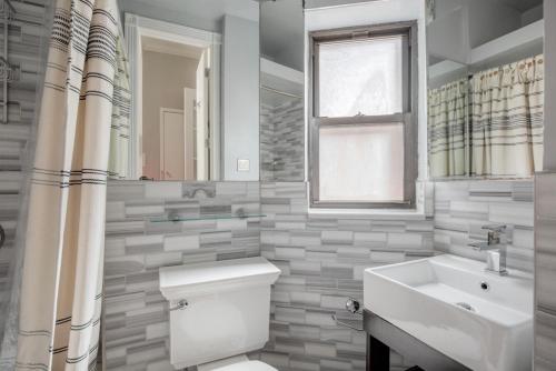 a bathroom with a toilet and a sink and a window at West Village 1br w wd nr local park NYC-1262 in New York