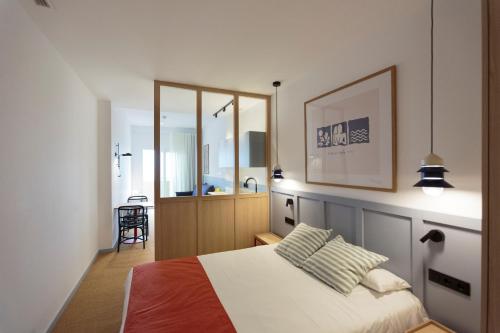 1 dormitorio con cama y espejo en Hotel Miramar Valencia, en Valencia