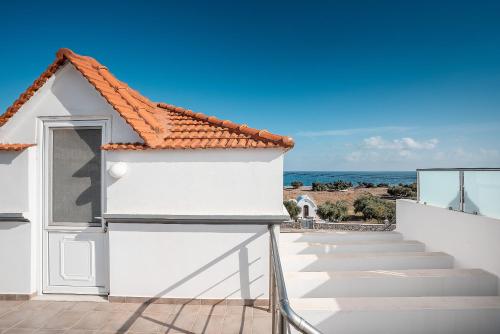 a white house with stairs leading to the ocean at Blue Pearl in Lachania