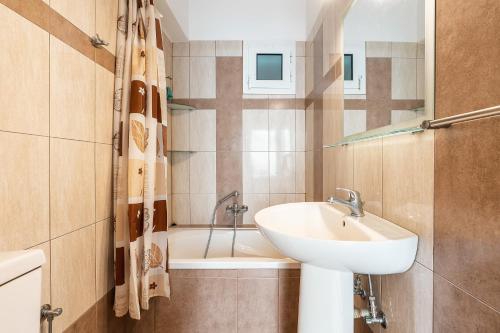 a bathroom with a sink and a bath tub at Blue Pearl in Lachania