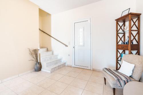 a living room with a staircase and a chair at Blue Pearl in Lachania
