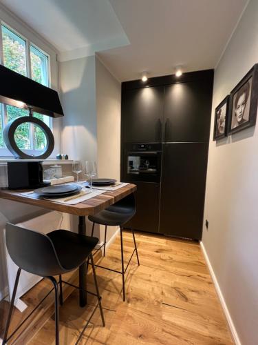 a kitchen with a table and chairs and a refrigerator at Premium Apartment an der Stadtmauer im EG in Paderborn