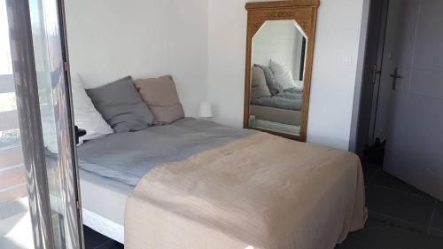 une chambre avec un lit et un miroir dans l'établissement Vacances au calme pour cette villa de standing proche du Golf - 4GOLFC10, à Saint Cyprien Plage