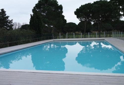 une piscine avec de l'eau bleue dans une cour dans l'établissement Vacances au calme pour cette villa de standing proche du Golf - 4GOLFC10, à Saint Cyprien Plage