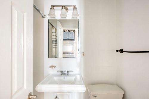 a white bathroom with a sink and a toilet at West Village 1br w wd nr park NYC-1275 in New York