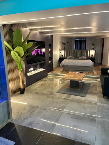 un salon avec un lit et une table dans l'établissement Anemos Spa & Loft Jacuzzi privatif, à Gargenville