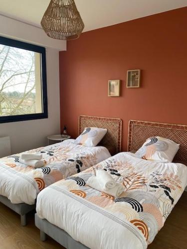 deux lits côte à côte dans une pièce dans l'établissement L'Echappée Belle, à La Séguinière