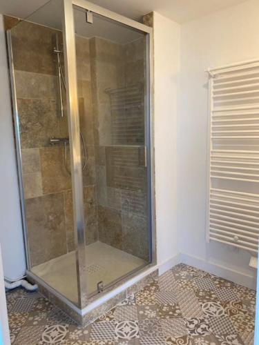 une douche avec une porte vitrée dans une salle de bain dans l'établissement L'Echappée Belle, à La Séguinière