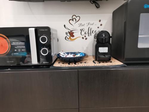 una encimera de cocina con microondas y un tazón de comida en PIGRO House - Bologna Airport Suite en Bolonia