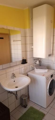 ein Badezimmer mit einem Waschbecken und einer Waschmaschine in der Unterkunft Wohlfühlen & Arbeiten in Toplage mit gratis Tiefgaragenplatz in Graz