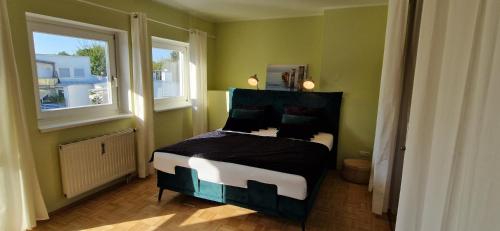 een slaapkamer met een bed in een kamer met 2 ramen bij Wohlfühlen & Arbeiten in Toplage mit gratis Tiefgaragenplatz in Graz