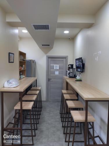 a bar with stools in a room with a door at Metro Hostel in Yerevan